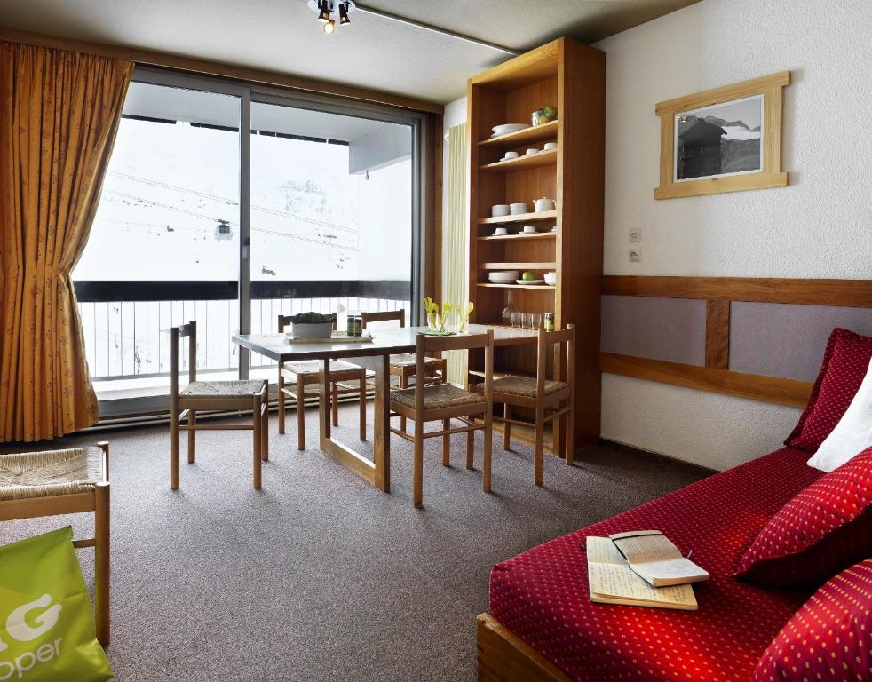 ヴァル・トランスにあるAbrineige Clubhotel Le Gypaète Val Thorensのリビングルーム(赤いソファ、テーブル付)