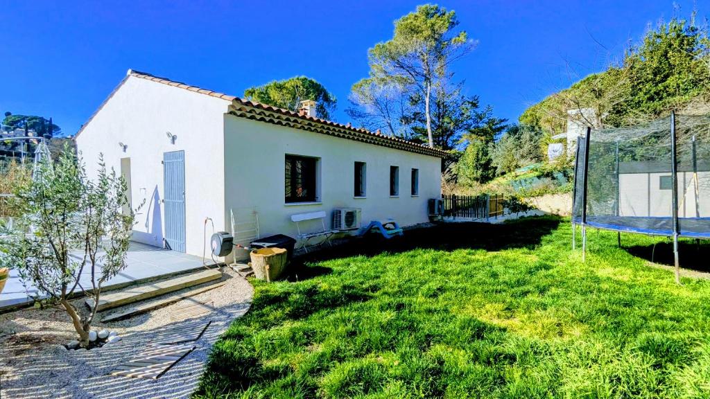 une petite maison blanche avec un panier de basket dans la cour dans l'établissement Haut de villa 2P, jardin, clim, prise VL Electrique, à Saint-Paul-de-Vence