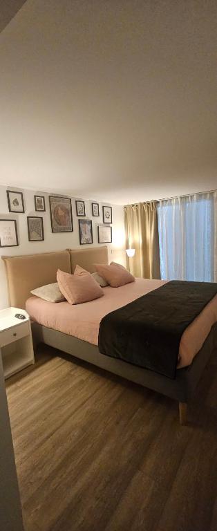 - une chambre avec un grand lit et des photos sur le mur dans l'établissement le stockholm, à Sablons