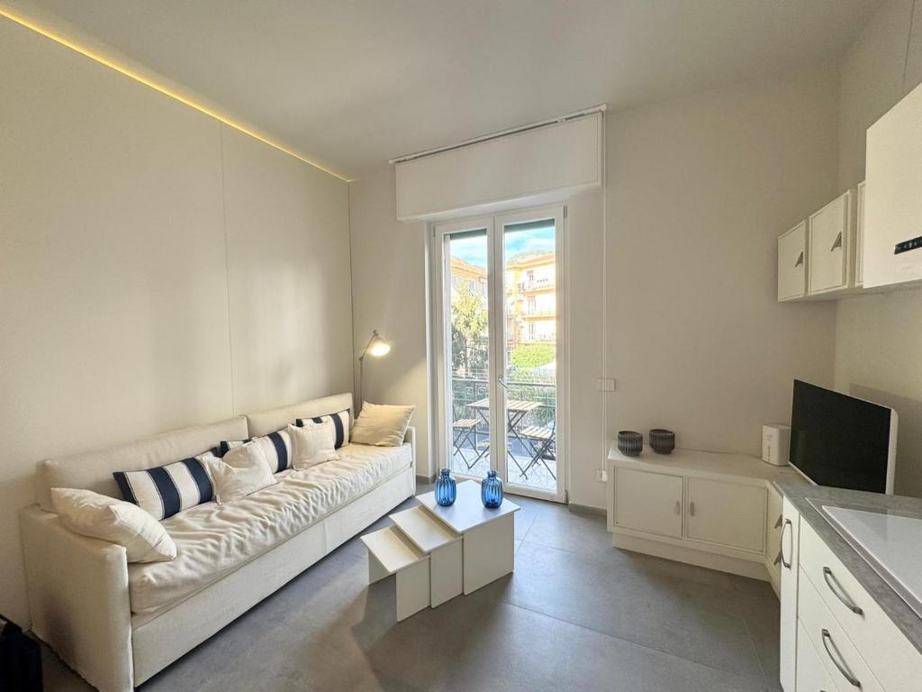 a white living room with a couch and a television at Casa Biba in Finale Ligure