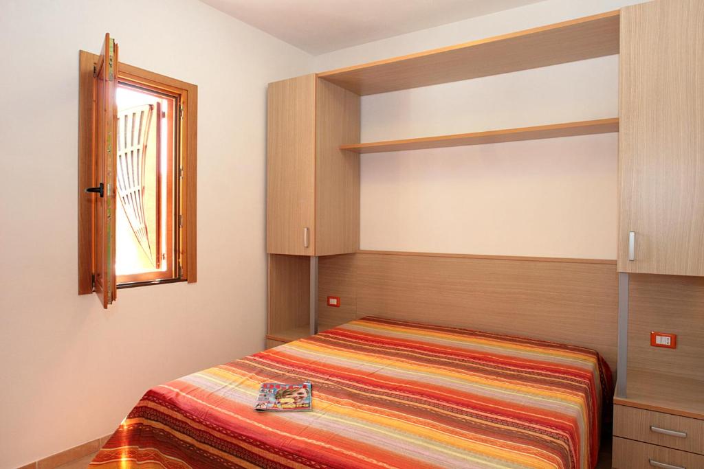 mała sypialnia z łóżkiem i oknem w obiekcie Relax w mieście Vieste