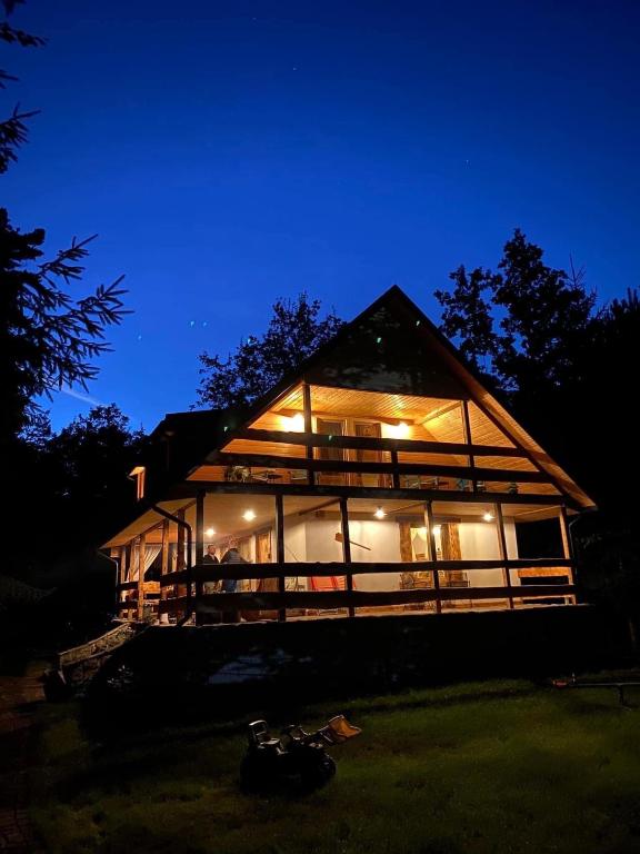 a house that is lit up at night at Domek Serce Lasu in Hutki