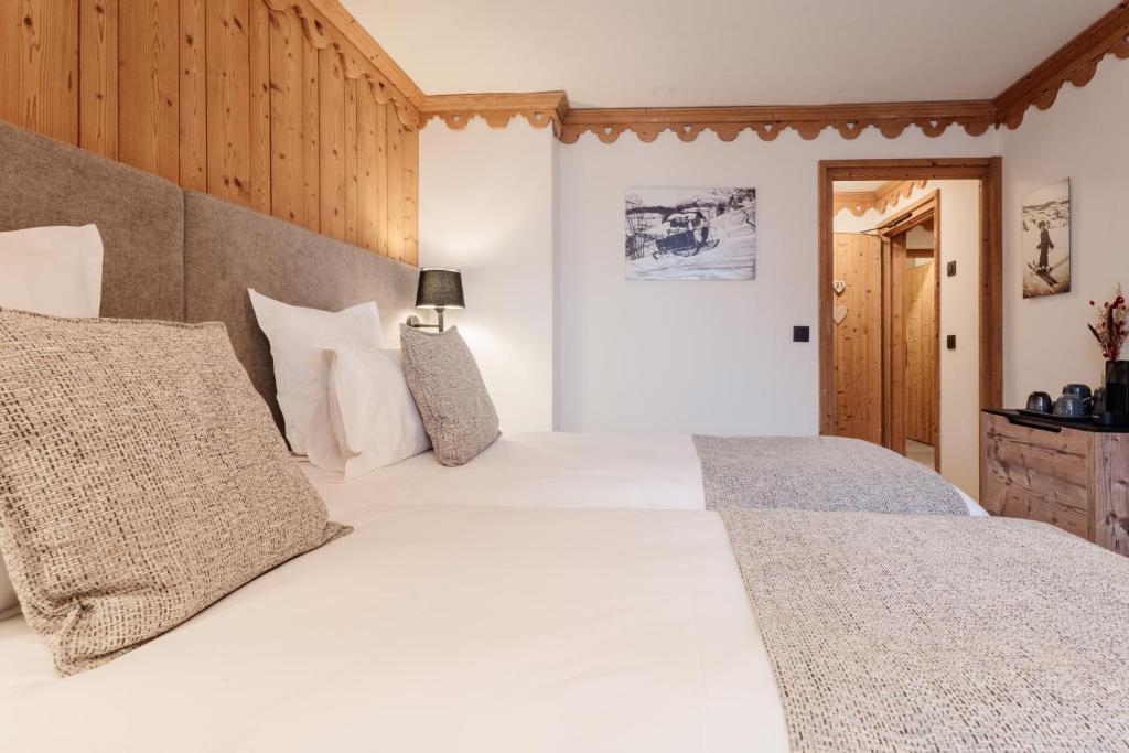 a bedroom with a large white bed with pillows at La Ferme du Golf in Megève