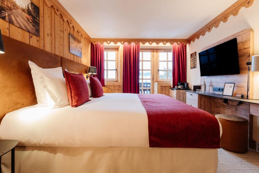 a hotel room with a bed and a television at La Ferme du Golf in Megève