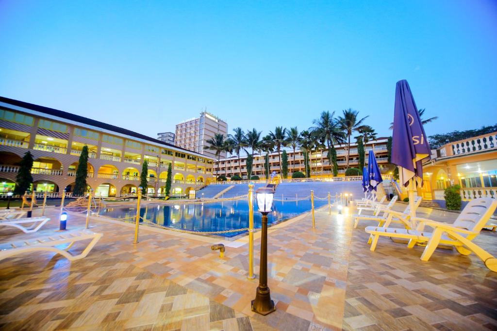 un resort con piscina, sedie e un edificio di Hotel Africana a Kampala