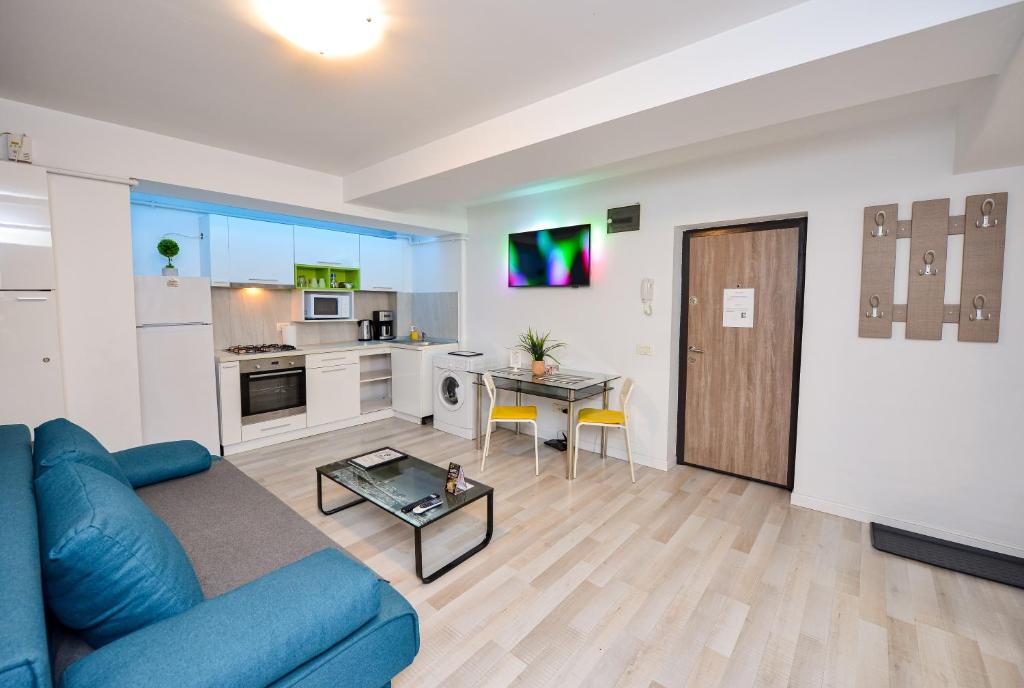 a living room with a blue couch and a kitchen at Harmony Residence in Bucharest