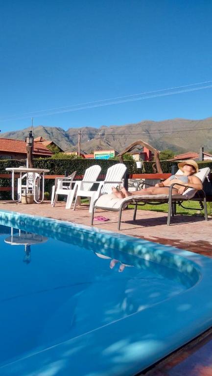 a group of people laying on lounge chairs next to a swimming pool at Gracias Viejo in Merlo