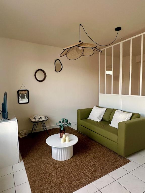 un salon avec un canapé vert et une table dans l'établissement Le Croix-Roussien - Apartment 30m2, à Caluire-et-Cuire