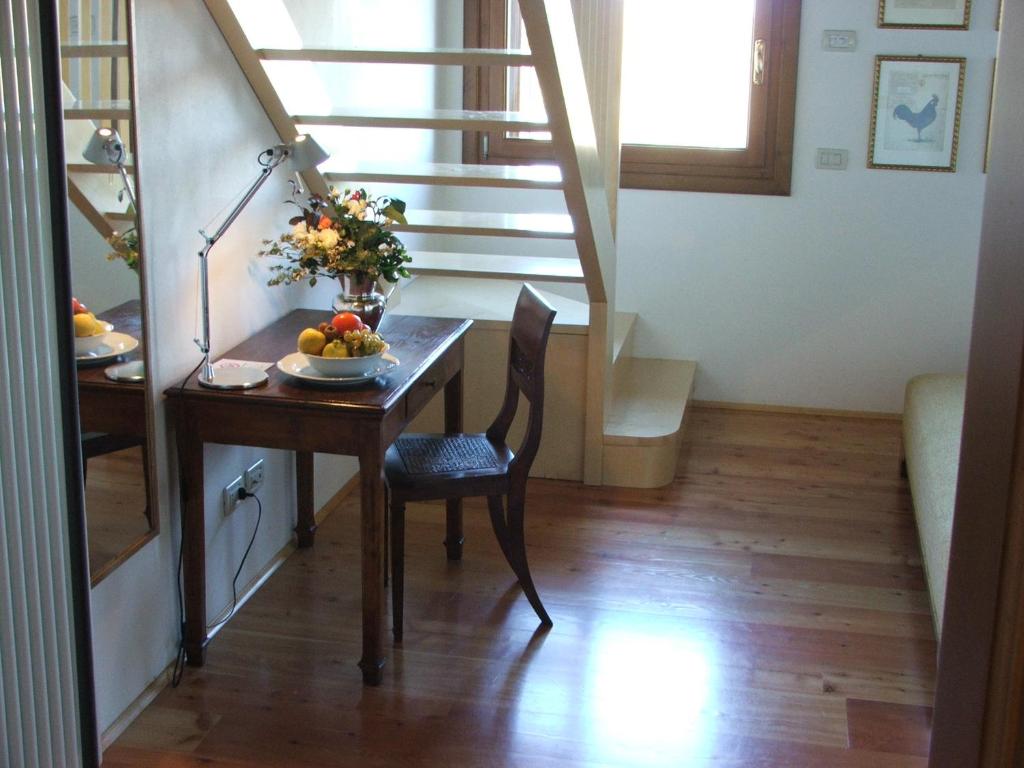 een kamer met een tafel met een fruitschaal en een trap bij Palazzetto Ardi in Torri di Confine