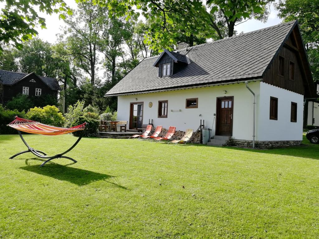 a house with a bench in front of a yard at Chalupa Rejvíz in Rejvíz