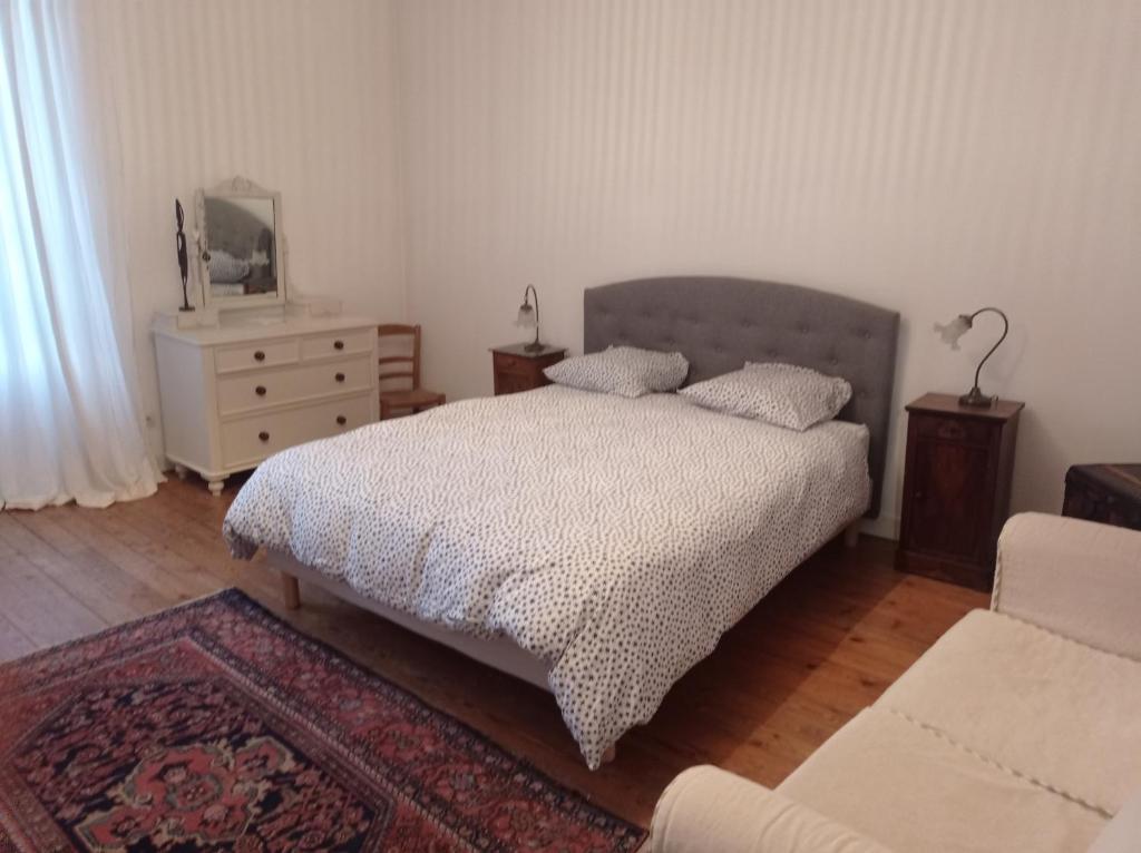 a bedroom with a bed and a dresser at La maison de Nina in Pont-Sainte-Maxence