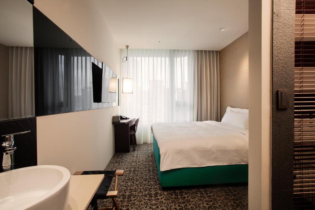 Postel nebo postele na pokoji v ubytování Lacle Hotel-Luzhou Taipei