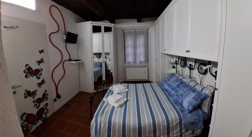 niewielka sypialnia z łóżkiem z narzutą do łóżka w obiekcie Il Sasso appartamento w mieście Orta San Giulio