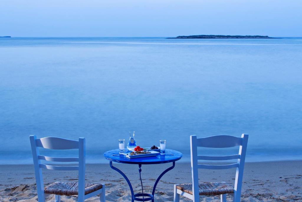 two chairs and a table on the beach at Contaratos Beach Hotel in Naousa