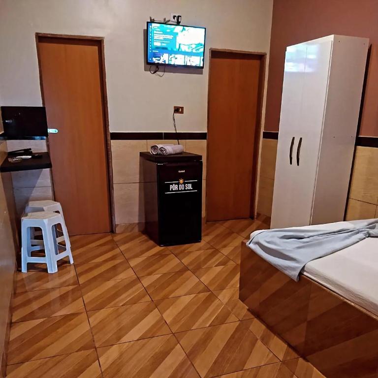 a room with a bed and a tv on the wall at Apartamentos Mobiliados - UFRPE-UABJ in Belo Jardim