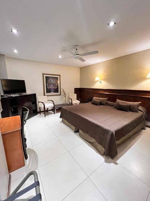 Un dormitorio con una cama y un televisor de pantalla plana. en Hotel Ciudad, en Santiago del Estero