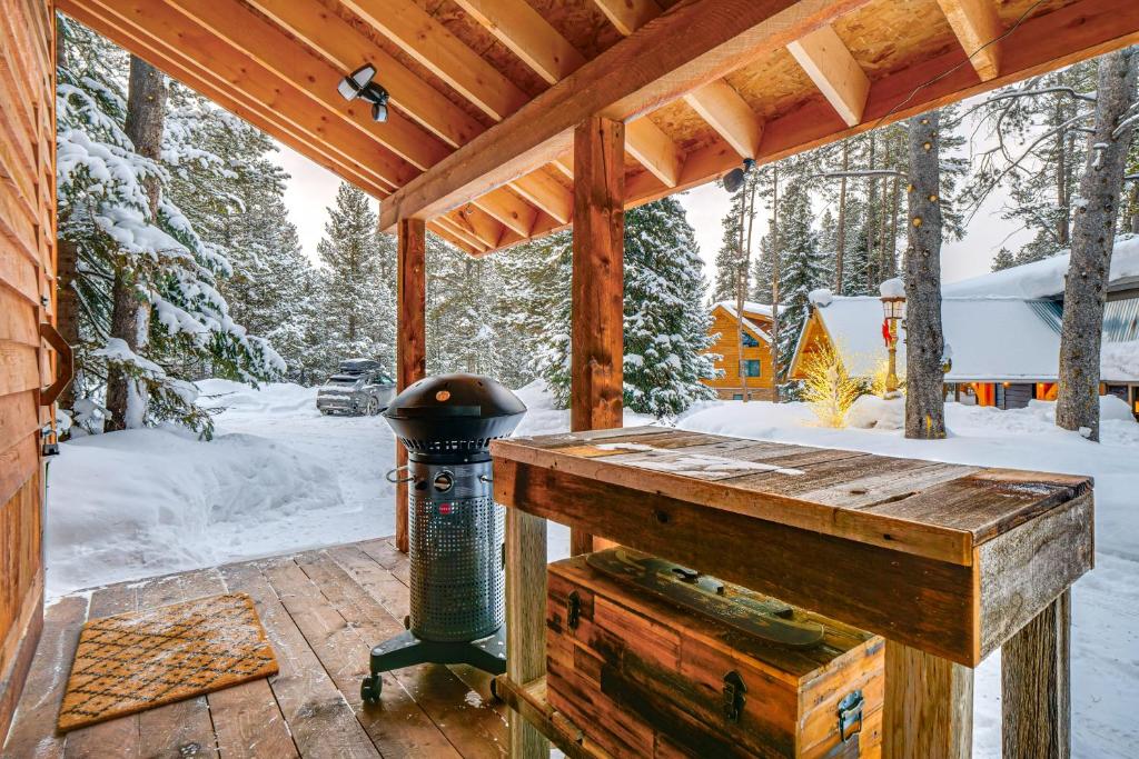 eine Holzveranda mit einem Grill im Schnee in der Unterkunft 5 Mi to Breckenridge Ski Resort Cozy Wood Cabin! in Breckenridge