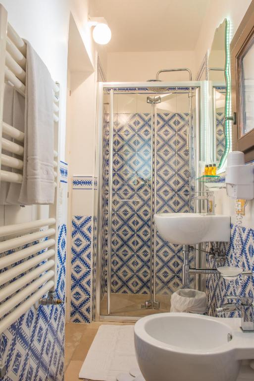 a blue and white bathroom with a sink and a shower at Dimora Dell'Osanna in Carovigno
