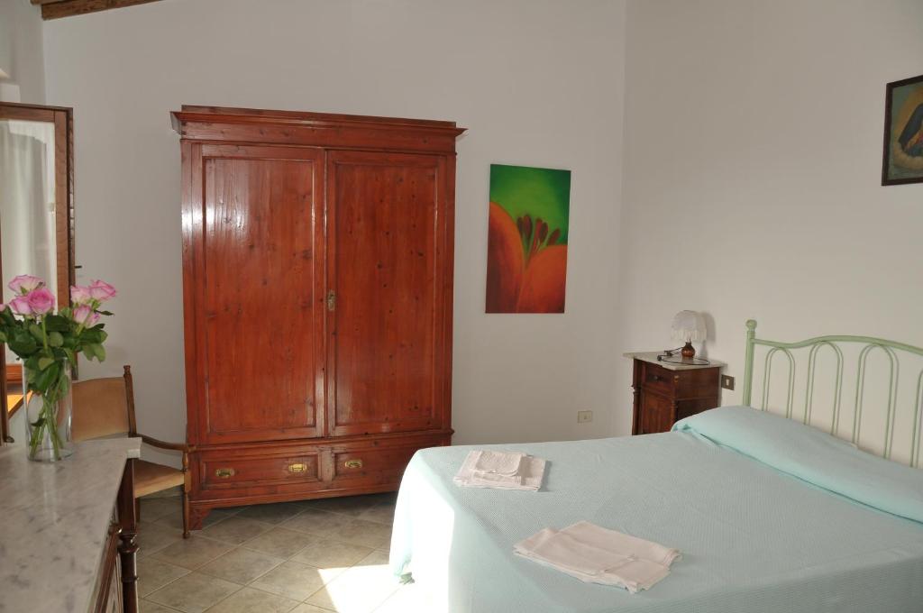 1 dormitorio con 1 cama y armario de madera en Agriturismo Renai e Monte, en Gambassi Terme