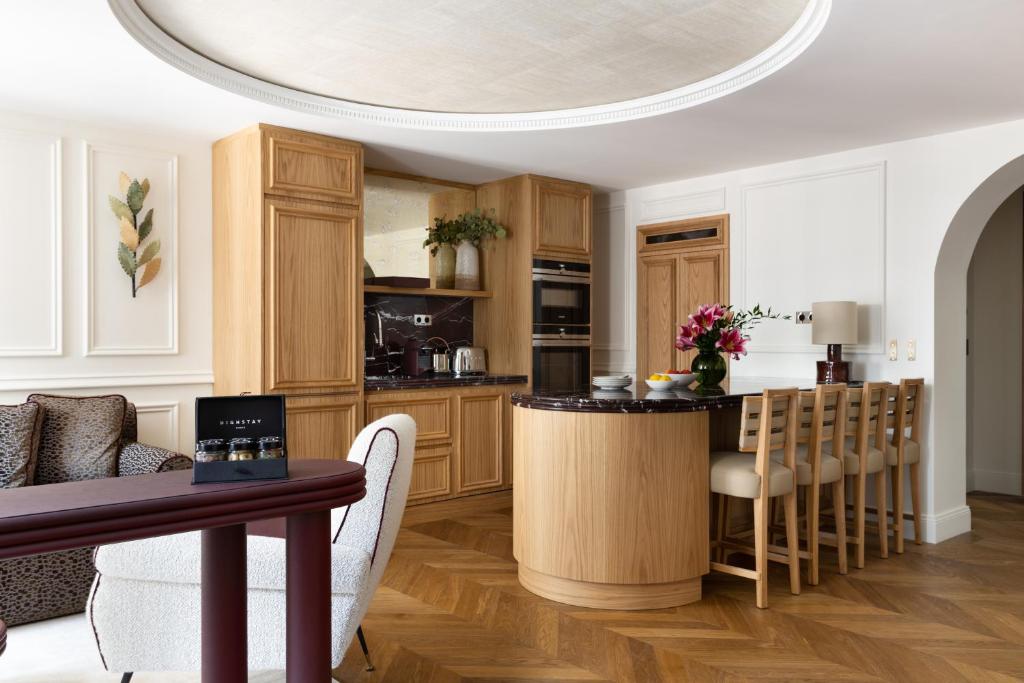 une cuisine avec des placards en bois et un îlot de cuisine dans l'établissement HIGHSTAY - Luxury Serviced Apartments - Victoires, à Paris