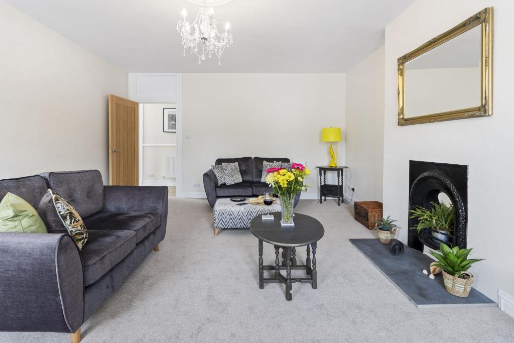 a living room with a couch and a table at The Heart of Brixham, Bolton Plaice, Luxury Apartment in Brixham