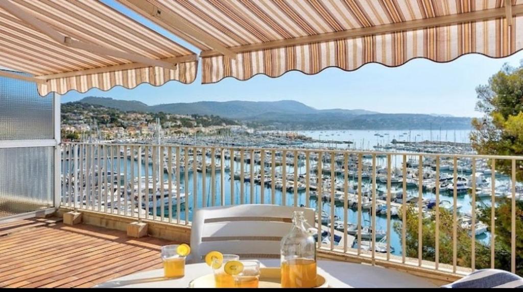 balcón con mesa y vistas al puerto deportivo en Résidence Bandol Port, en Bandol