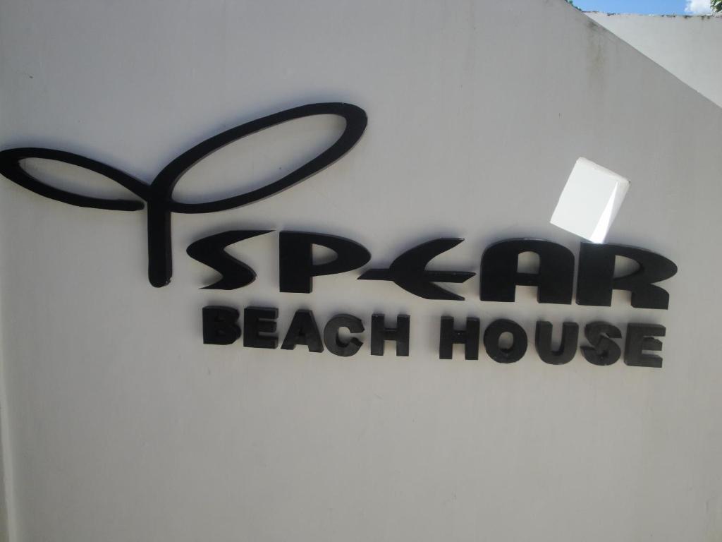 a sign for a spa beach house on a wall at Spear Beach House in Kuta Lombok