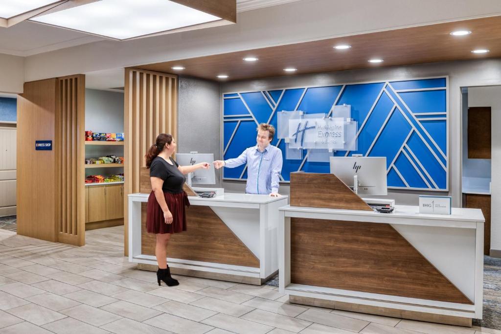 a man and a woman standing at a counter at Holiday Inn Express & Suites - Green Bay East by IHG in Green Bay