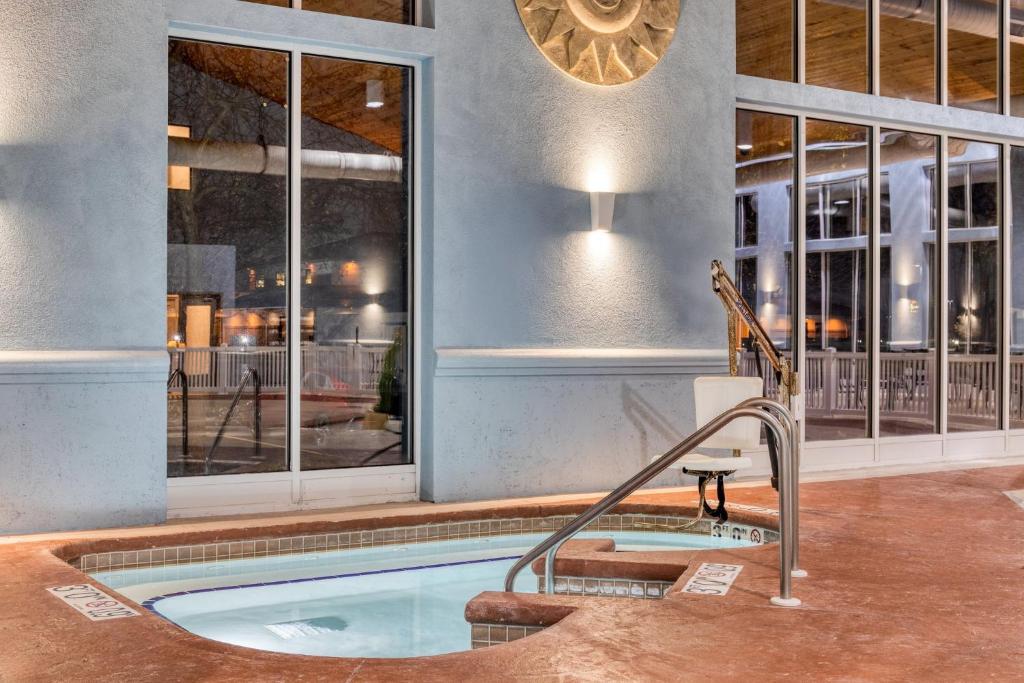 a swimming pool with a hot tub in a room with windows at Holiday Inn Express & Suites - Green Bay East by IHG in Green Bay
