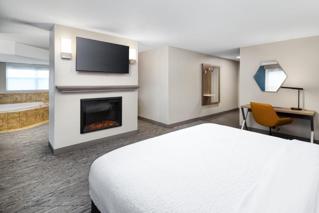 a hotel room with a bed and a fireplace at Holiday Inn Express & Suites - Green Bay East by IHG in Green Bay