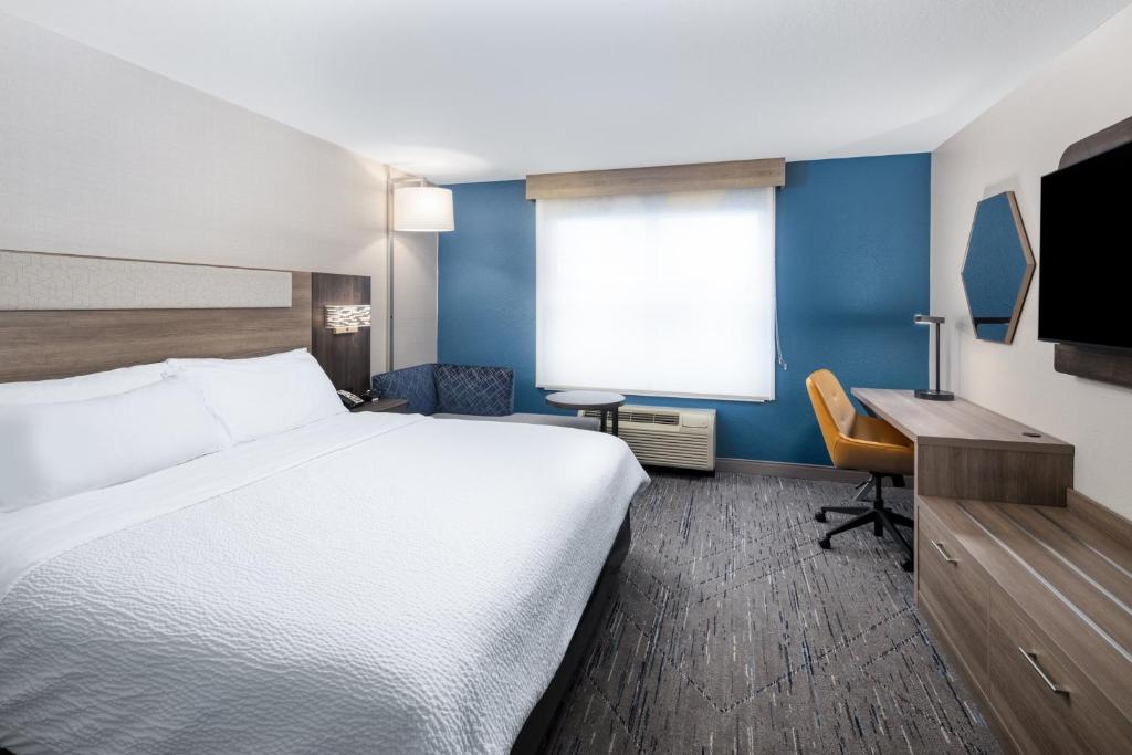 a hotel room with a bed and a desk at Holiday Inn Express & Suites - Green Bay East by IHG in Green Bay