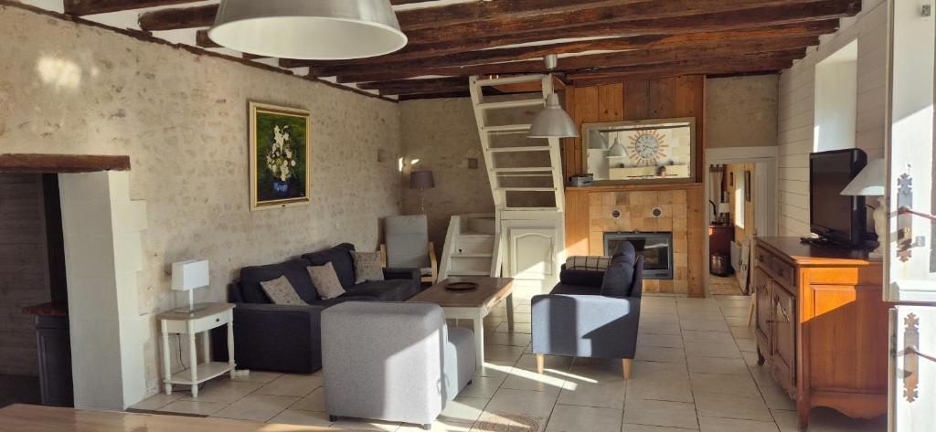 a living room with a couch and a table at Ma Demoiselle d'Oé - maison climatisée -3 étoiles in Notre-Dame-dʼOé