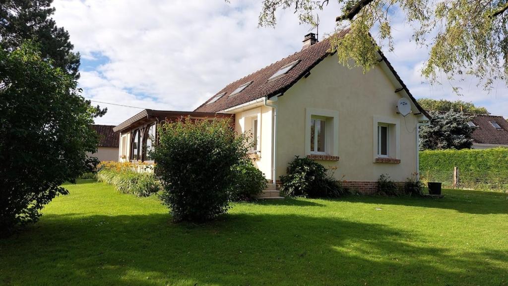 une petite maison blanche avec une cour gazonnée dans l'établissement Maison familiale avec salle de jeux, à Nabringhen
