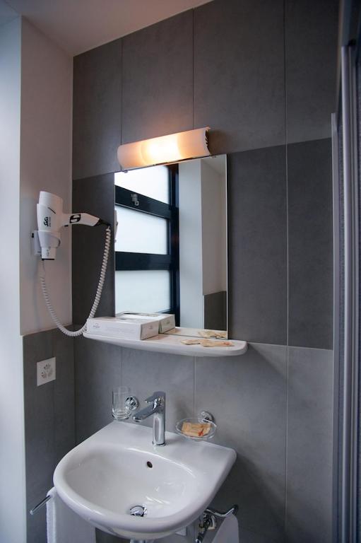ein Badezimmer mit Waschbecken und Spiegel in der Unterkunft Hotel Ceresio in Lugano