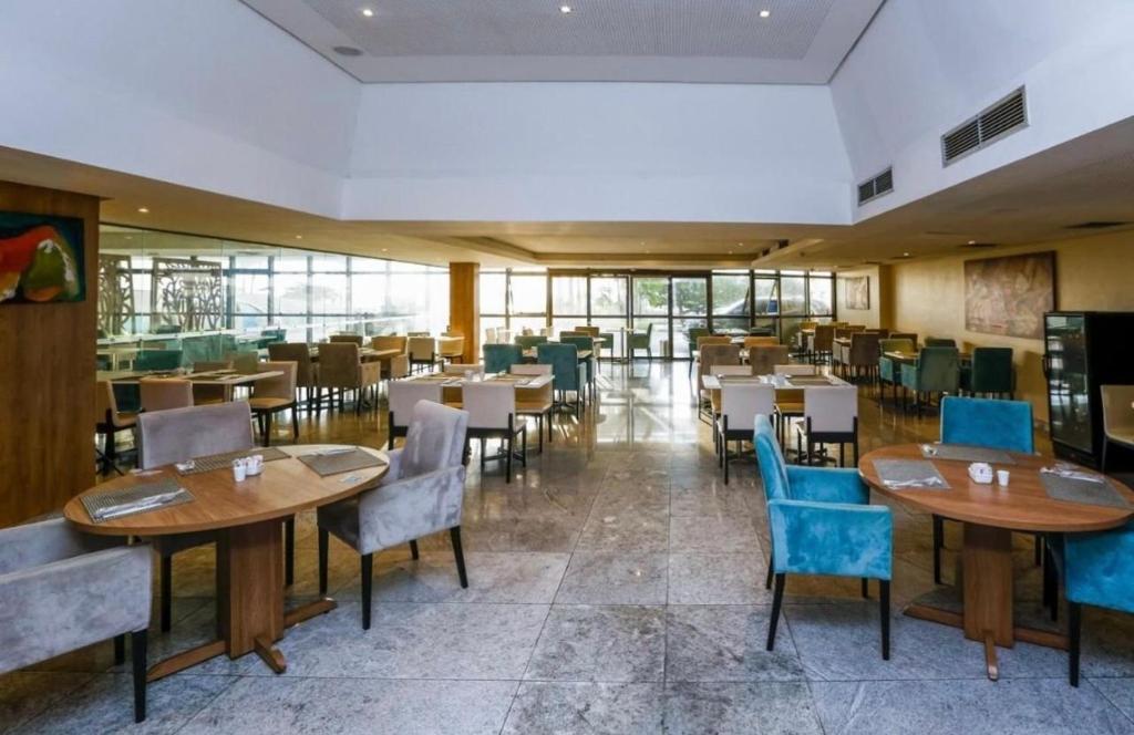 a restaurant with tables and chairs in a room at Beach Class International - Beira Mar - Boa Viagem in Recife