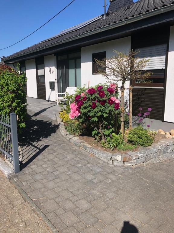 a house with pink flowers in front of it at Ferienwohnung Barbara in Kirchhundem