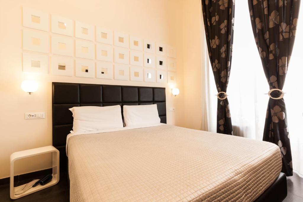 um quarto com uma cama com uma cabeceira preta em Deko Rome em Roma