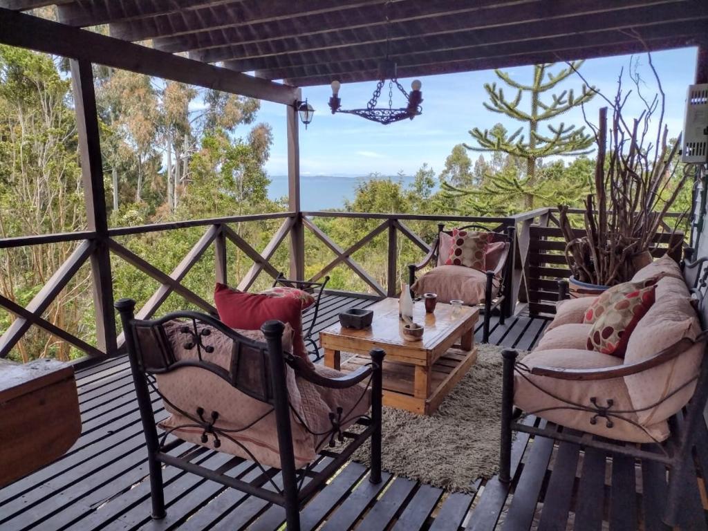 a porch with chairs and a table and a view at Casa costa Panitao, Puerto Montt in Puerto Montt