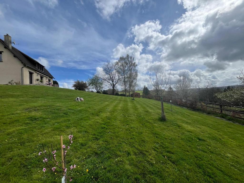 une maison sur une colline avec un champ vert dans l'établissement Maison entre mer et campagne, à Douville-en-Auge