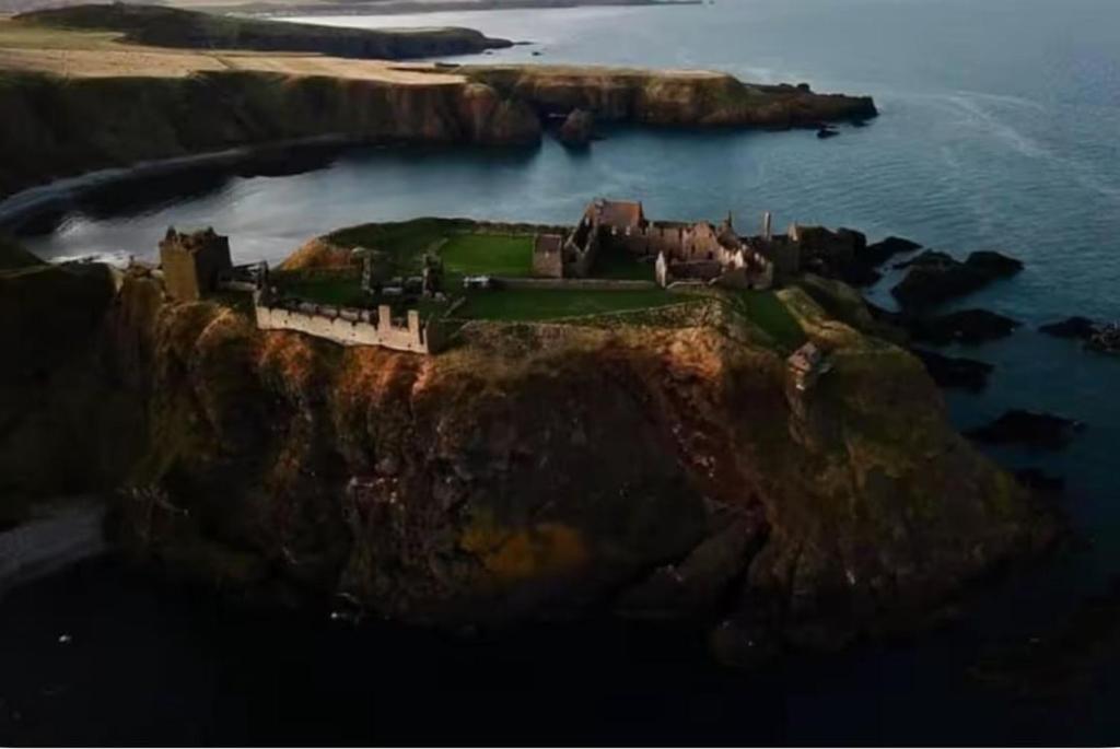 a castle on a cliff in the ocean at Stonehaven Centre - Dunnottar Apartment in Stonehaven