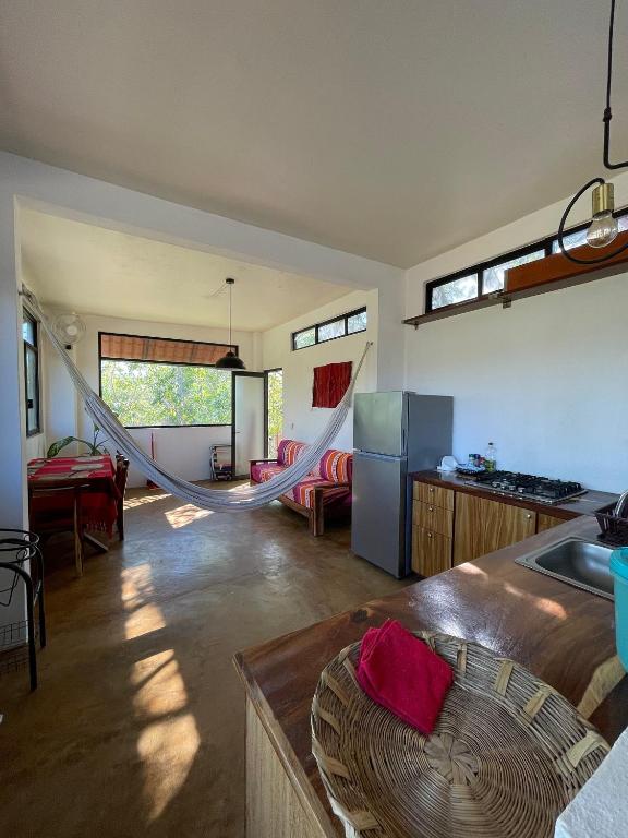 a kitchen with a hammock in the middle of a room at Centro Sati Bungalow in Cuatunalco