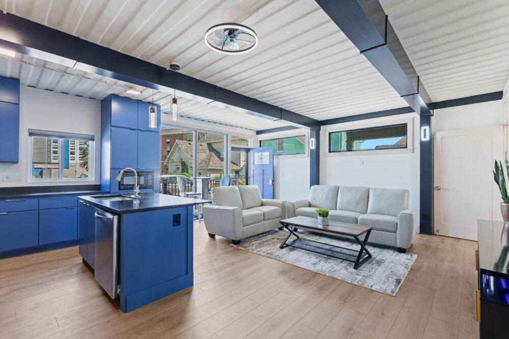 Una cocina y sala de estar con gabinetes azules y una mesa. en Indy Stadium Villa 711 L, en Indianápolis