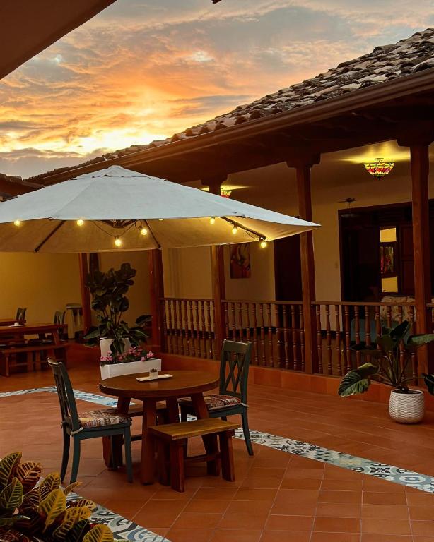 皮塔利托Hotel Colonial Andino - Parque principal de Pitalito的带桌椅和遮阳伞的露台