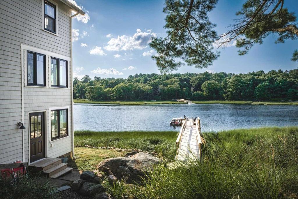 a house with a dock next to a lake at Stay at Little River in Gloucester