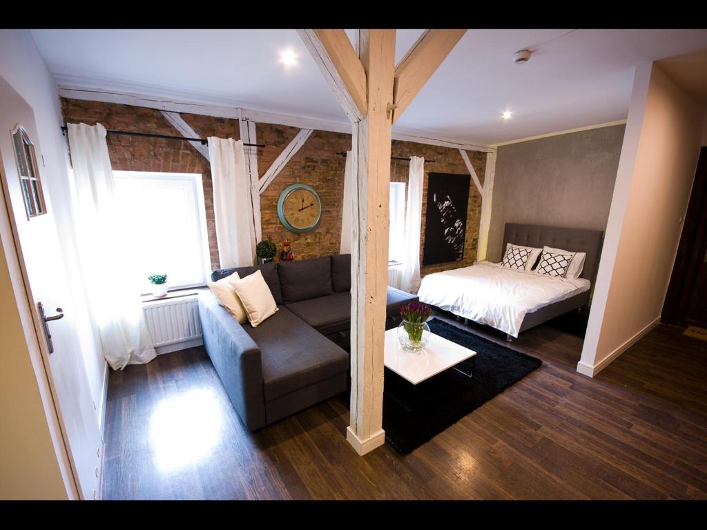 un soggiorno con divano e letto di Apartmenty Mariacka 20 -Self Check-In 24h -Loud on the weekends - by Kanclerz Investment a Katowice