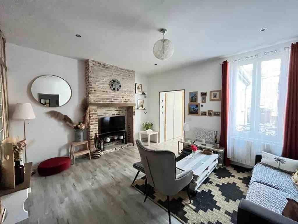 un salon avec un canapé et une cheminée dans l'établissement Appartement avec terrasse a 10min a pied du centre et de la gare, à Troyes