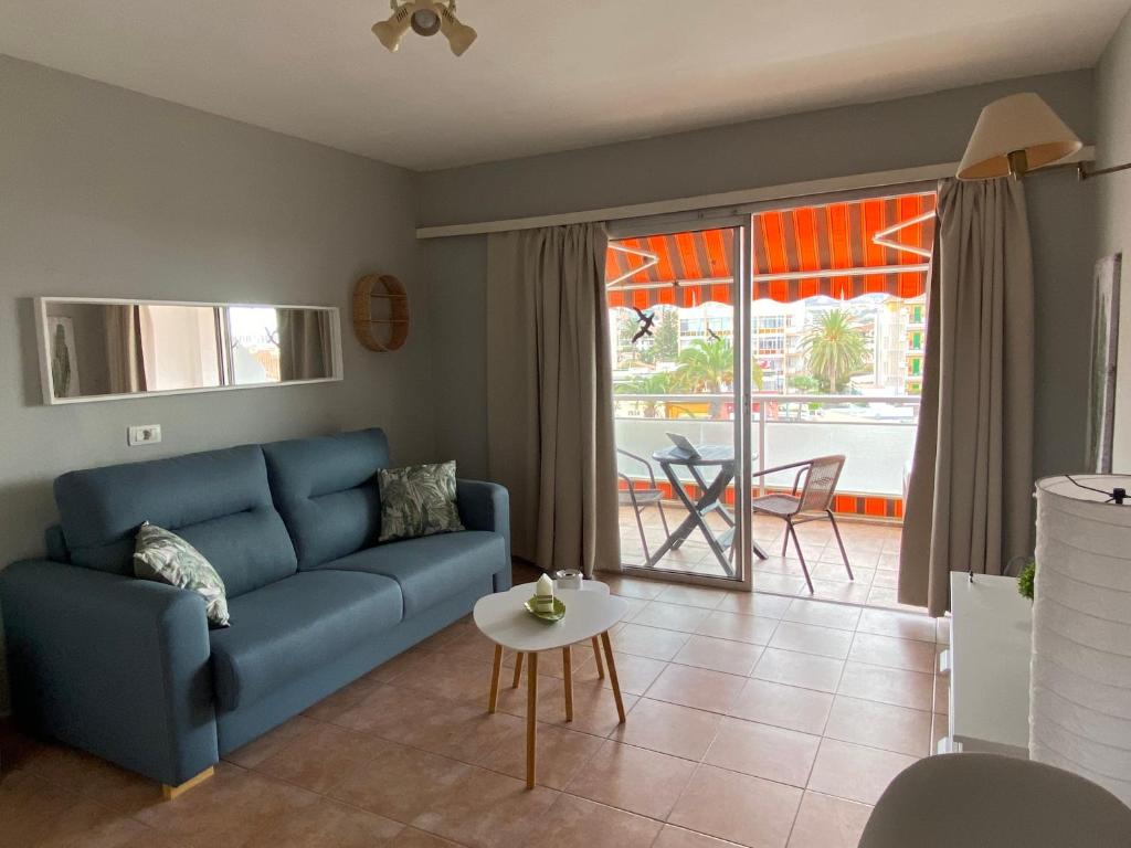 Una sala de estar con un sofá azul y una mesa. en Aceviño Solimar, en Puerto de la Cruz