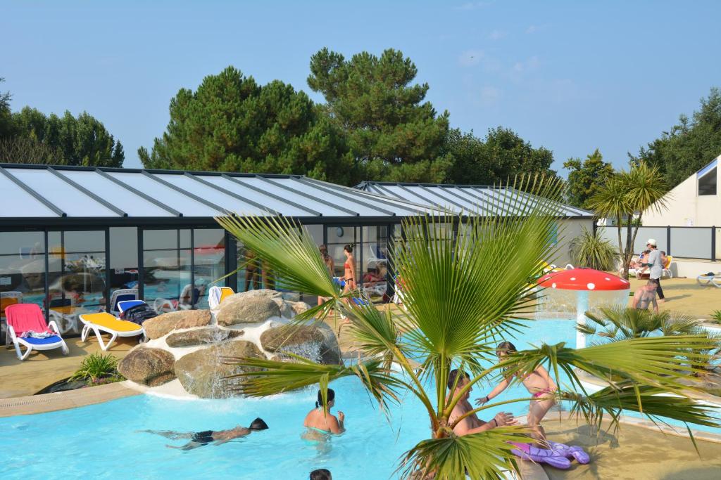 um grupo de pessoas na piscina de um resort em Camping La Touesse em Saint-Lunaire