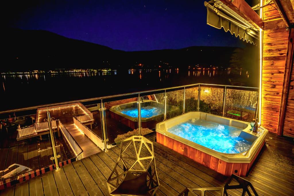 two hot tubs on the deck of a boat at night at Białe Molo - Domki & SPA in Międzybrodzie Bialskie