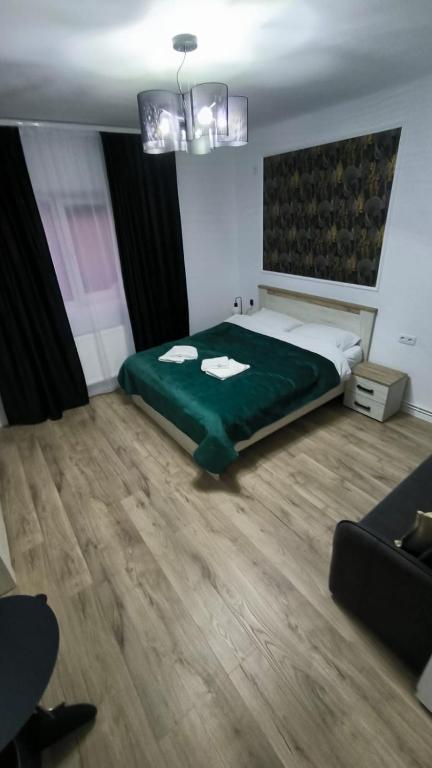 a bedroom with a large bed with a green blanket at Salin Gold Ap in Turda